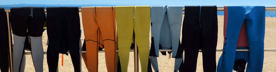 wetsuits drying at the beach