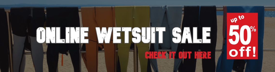 wetsuits drying at the beach